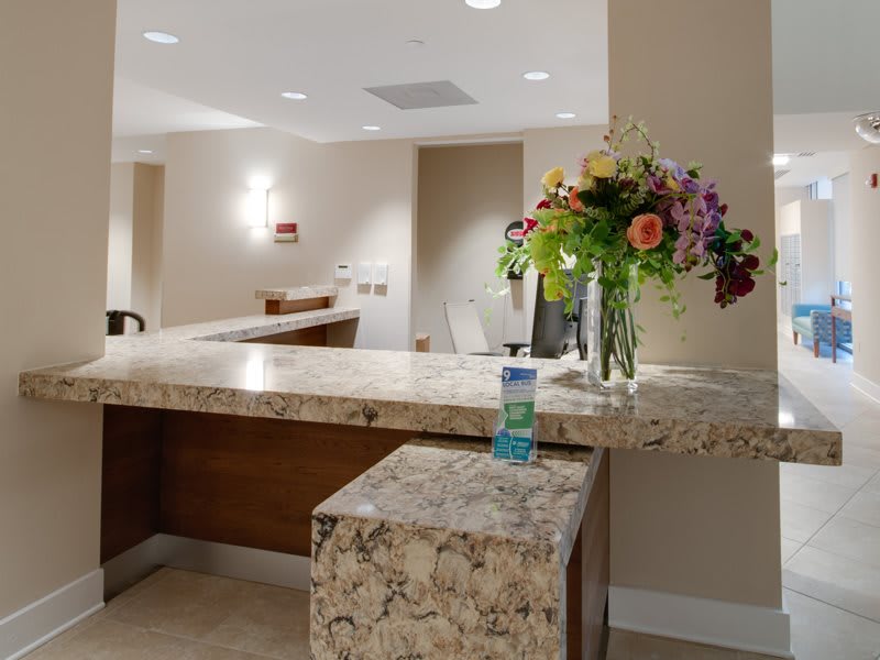 A reception desk adorned with a bouquet of flowers in an office setting.