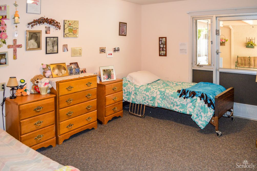 A cozy bedroom with a single bed, dressers, and wall decorations.
