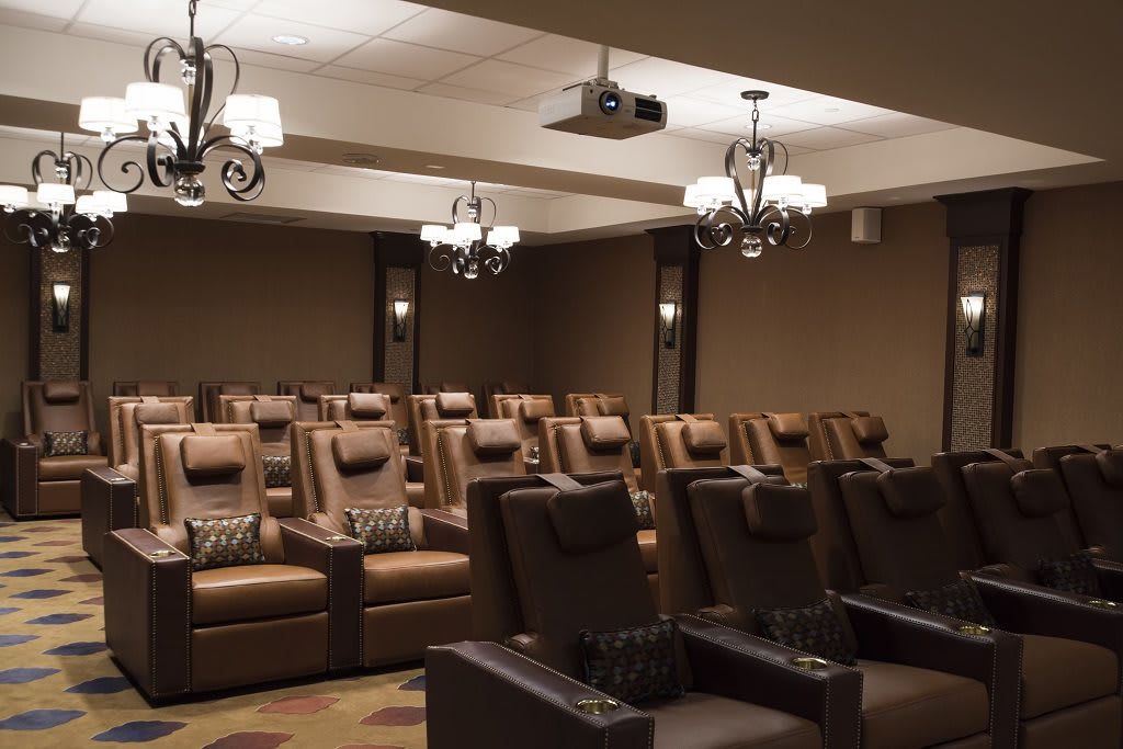 A luxurious home theater room featuring plush recliner seating and elegant lighting.