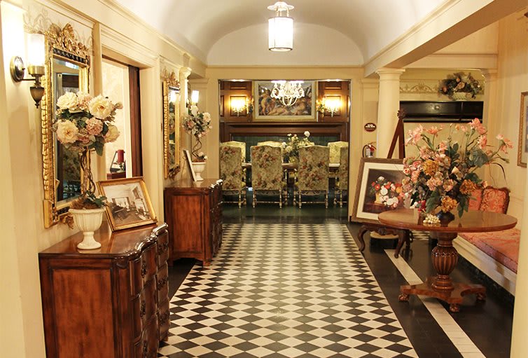 A vintage-styled hallway featuring a checkered floor and classic decor elements.