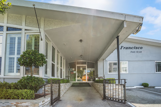 The inviting entrance of a modern building, featuring clean lines and well-maintained landscaping.
