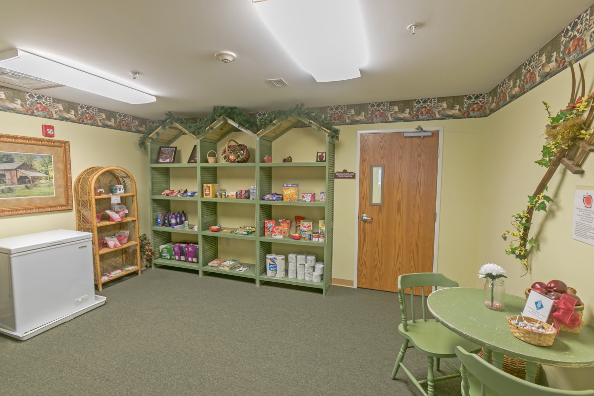 A cozy store interior with shelves displaying various products, accompanied by a table and chairs.