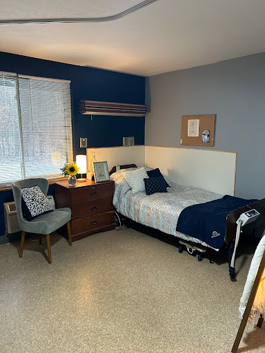 A cozy and organized bedroom featuring a single bed, desk, and comfortable seating.