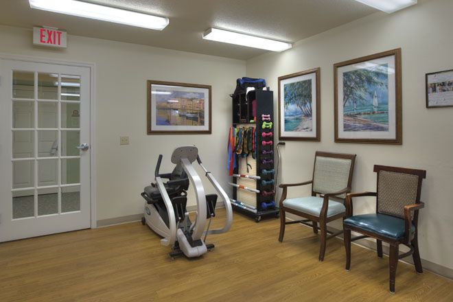 A small therapy room with exercise equipment and chairs.