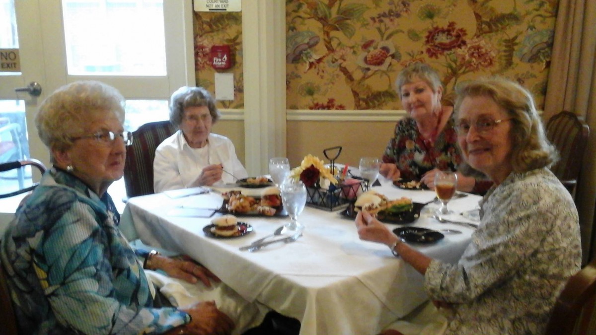 A group of elderly people enjoying a meal together at a restaurant.