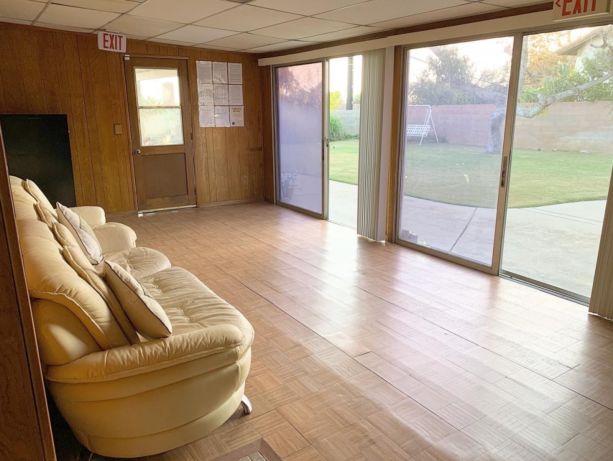 A spacious living room with hardwood floors, large sliding glass doors, and a comfortable sofa.