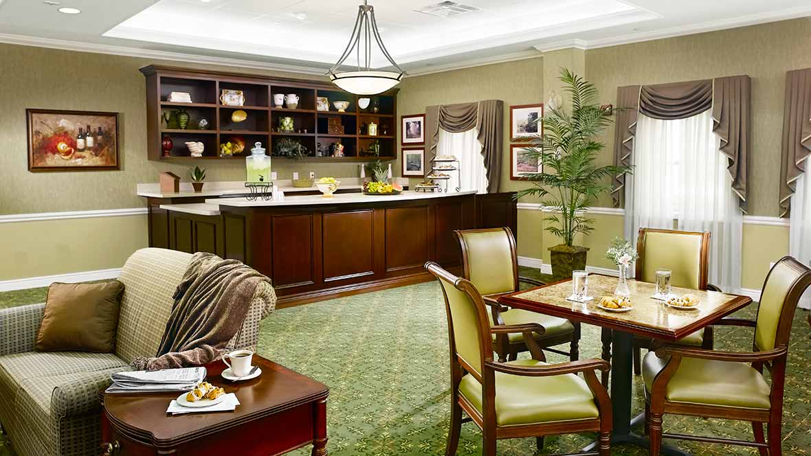 An elegant and spacious living room with a kitchen area, featuring classic furniture and tasteful decor.