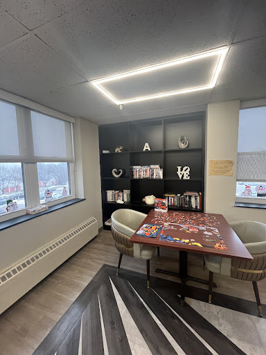 A modern office space featuring a collaborative table and shelving, designed to foster creativity.