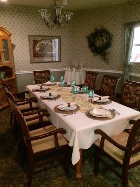 A formal dining room with a neatly set table and elegant chairs.
