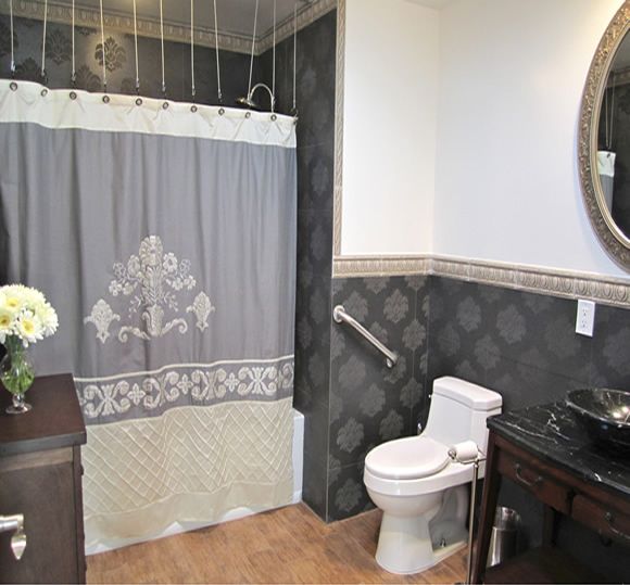 A well-decorated bathroom with a shower curtain, toilet, and sink with a mirror.