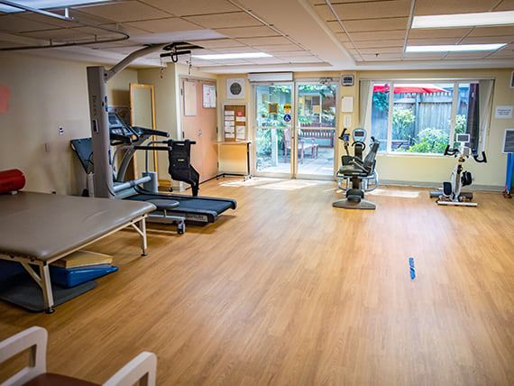 A well-lit exercise room equipped with a treadmill and stationary bike.