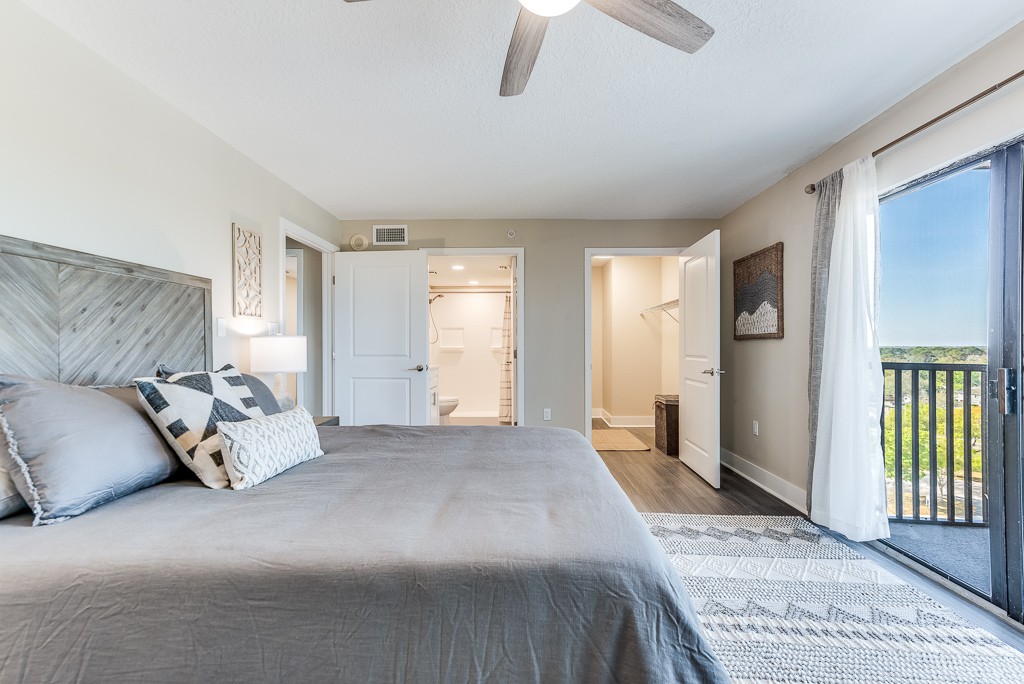A modern and minimalist bedroom featuring a large bed, stylish decor, and a ceiling fan.