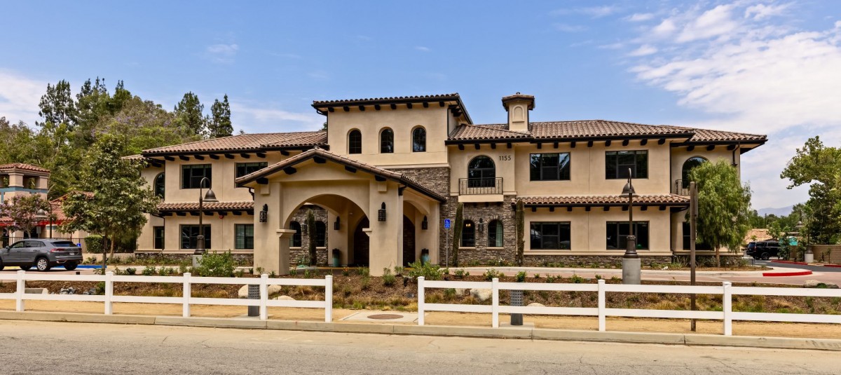 A Mediterranean-style luxury house with a spacious front yard.