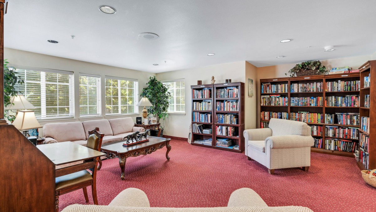 A cozy living room with bookshelves and comfortable seating.