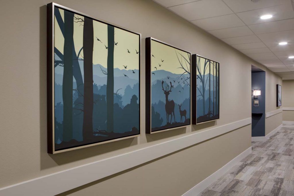 A triptych painting in a hallway depicts a serene forest scene with deer.