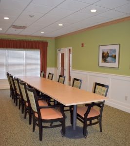 A spacious conference room with a long table and multiple chairs, suitable for meetings.