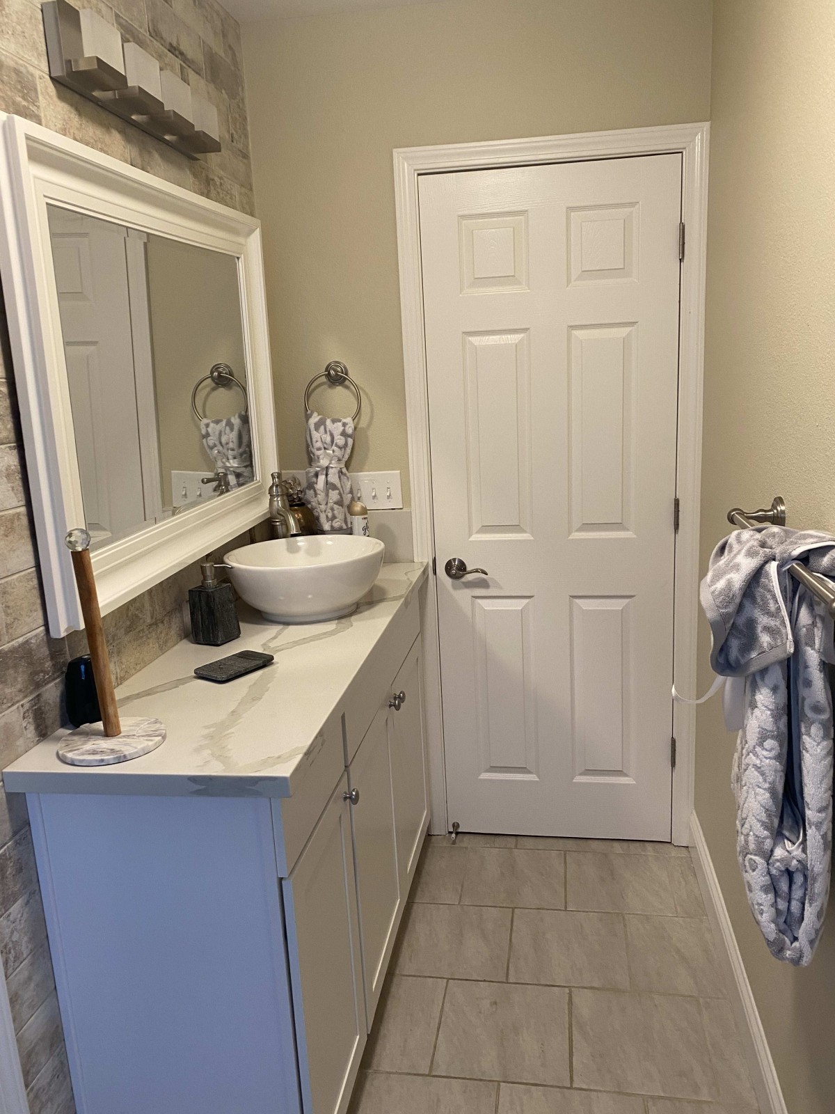 A modern bathroom with a vessel sink and decorative mirror.