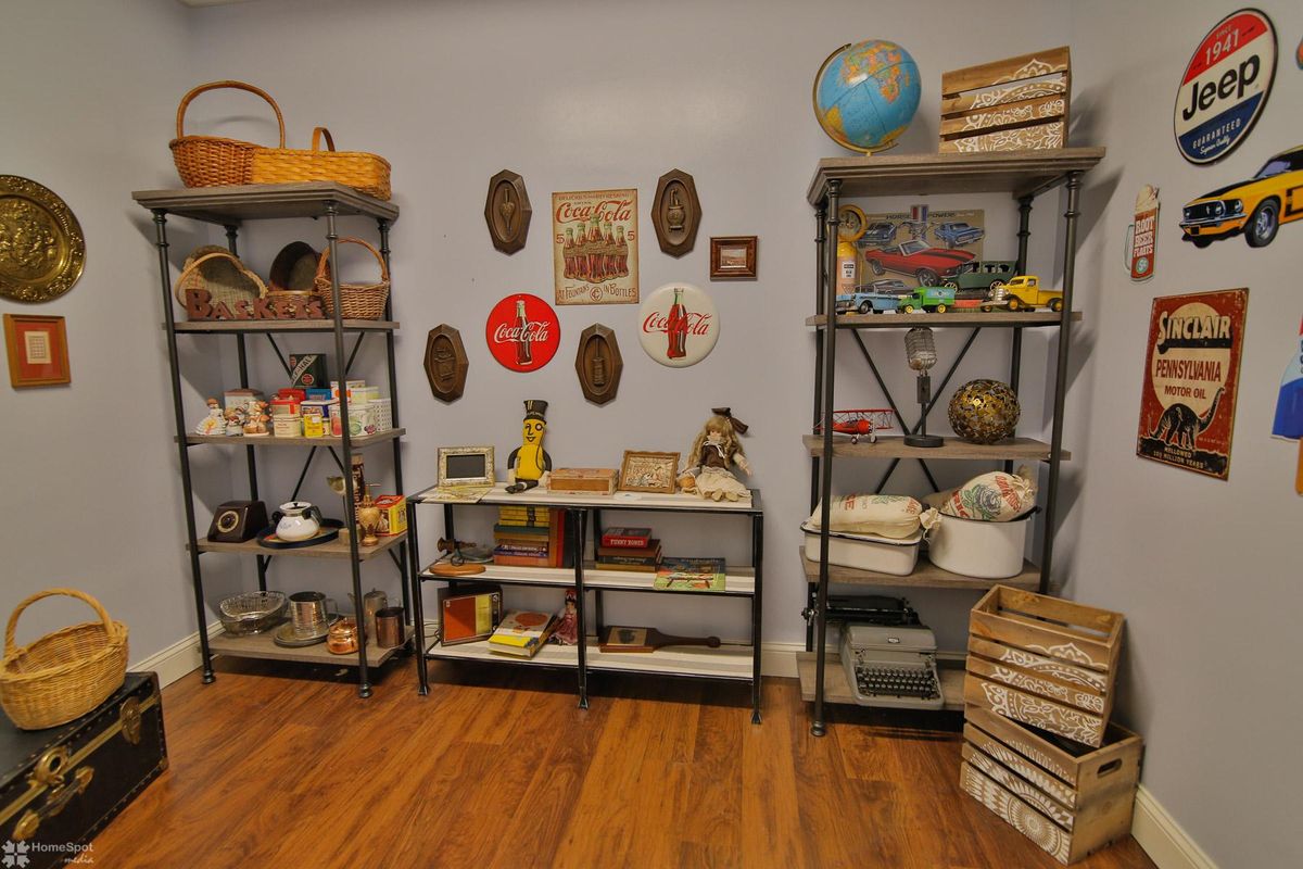 A cozy room featuring vintage shelves filled with books, antiques, and decorative items.