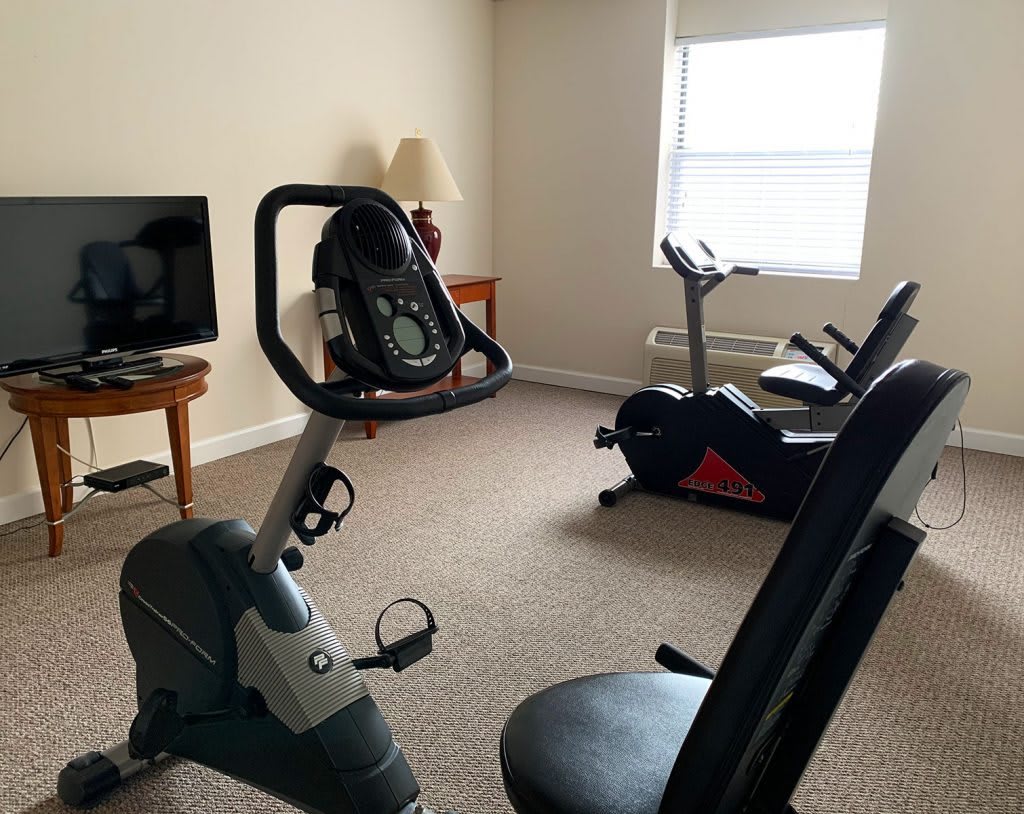 A home exercise room featuring stationary bikes and a television.