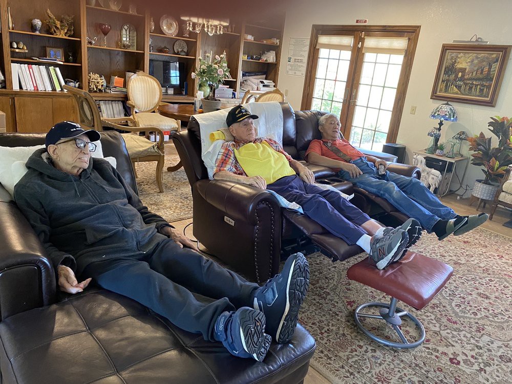 Three people relaxing on recliners in a cozy living room.