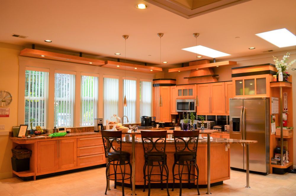 A modern kitchen with wooden cabinets and a central island equipped with stools.