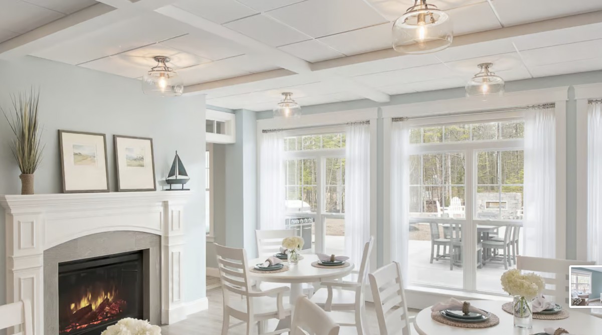 A bright and modern living and dining area with white furnishings and large windows.