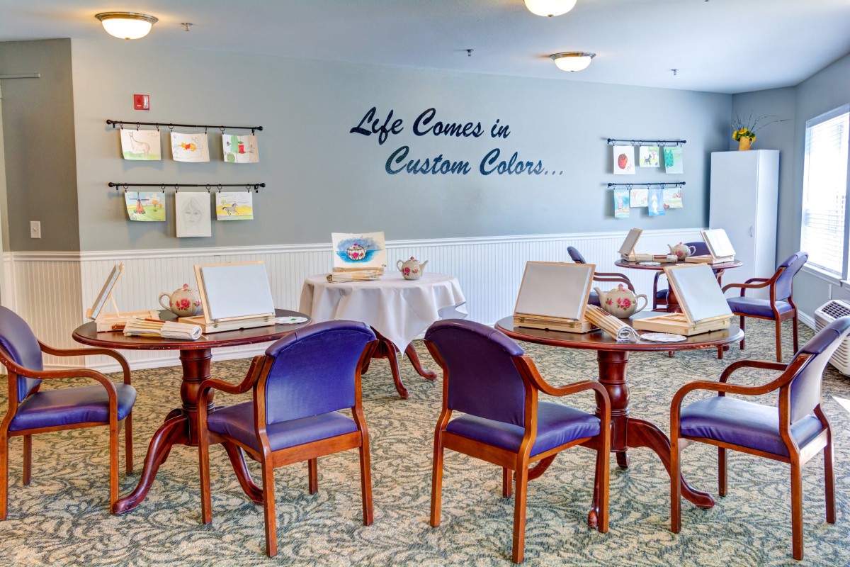 A colorful art room with tables and chairs set up for creative activities.