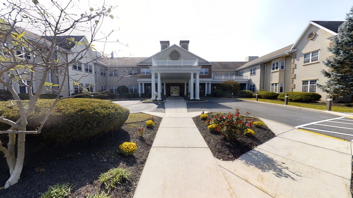 A symmetrical building entrance with a landscaped pathway leading up to it.
