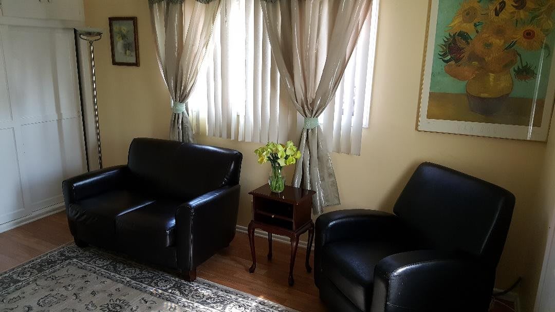 A cozy living room with leather seating and a floral centerpiece.