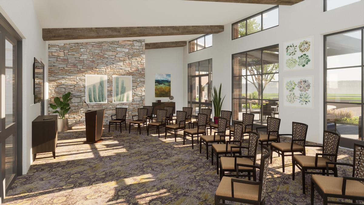 A well-lit conference room with chairs arranged for a presentation, featuring large windows and indoor plants.