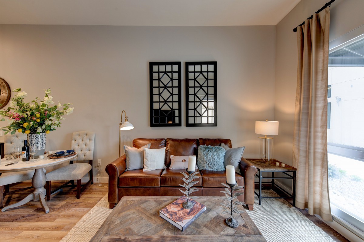 A cozy living room featuring a brown sofa adorned with pillows, a coffee table, and dual lamps providing a warm ambiance.