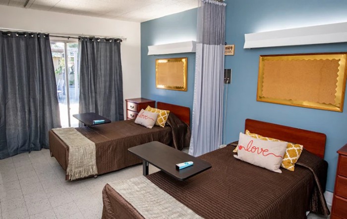 A cozy and well-decorated bedroom with twin beds and a blue accent wall.