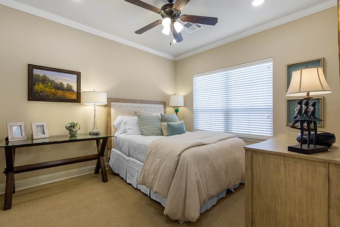 A cozy and well-lit bedroom with soft colors and stylish decor.
