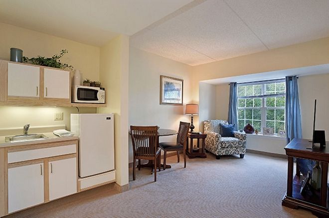 A bright and cozy living space featuring a kitchenette and comfortable seating area.