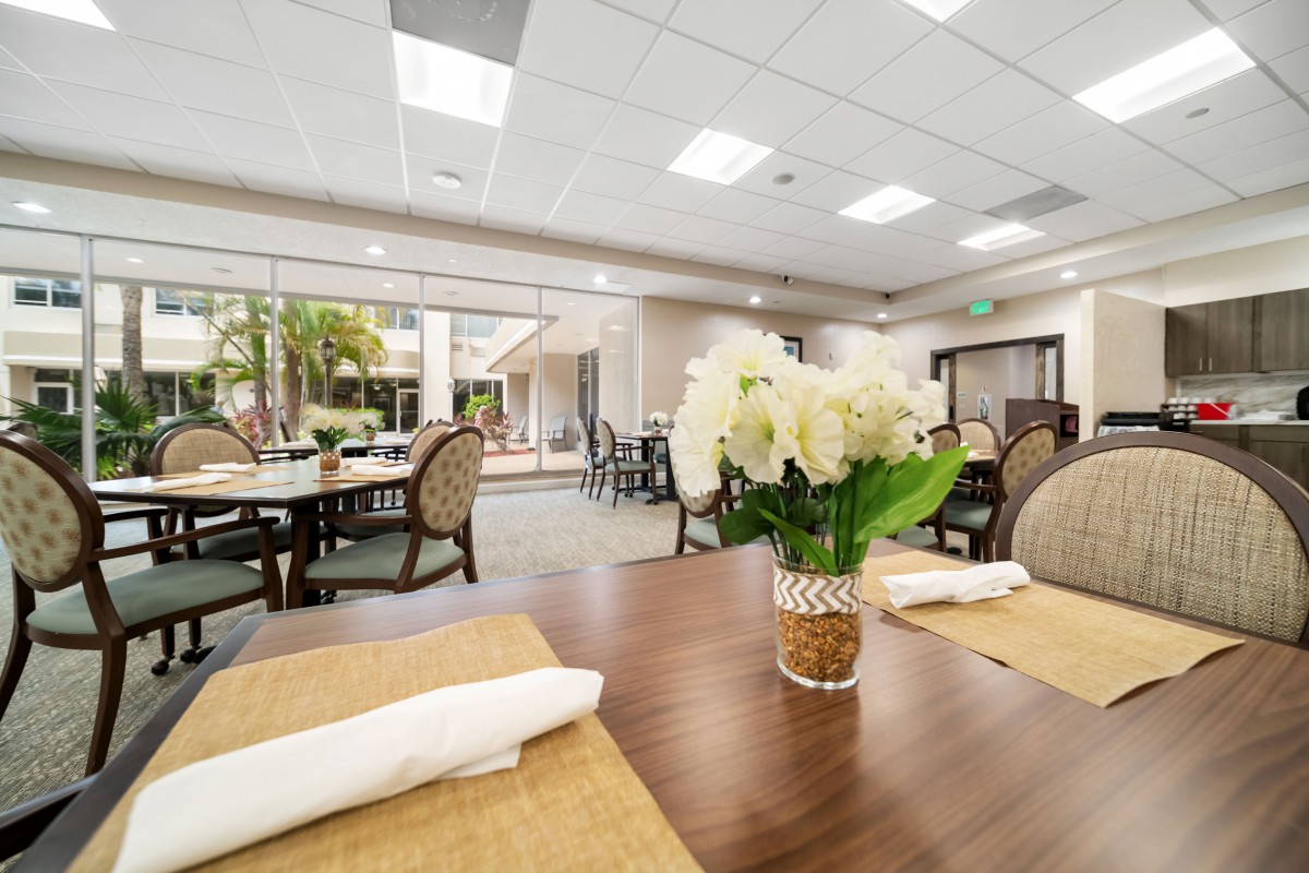 A bright and elegant restaurant dining area with neatly arranged tables, adorned with floral centerpieces.