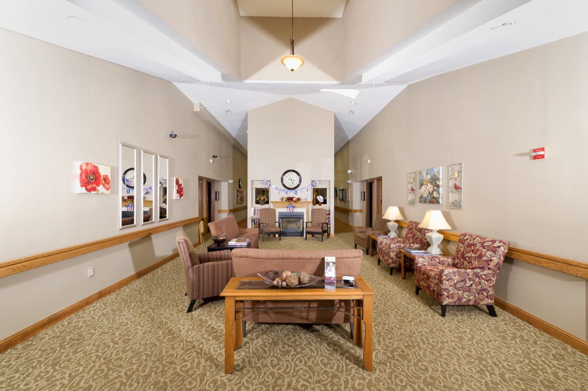 A cozy living room area with sofas, chairs, tables, and decorative elements.
