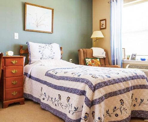 A cozy bedroom with a single bed adorned with a patterned quilt.