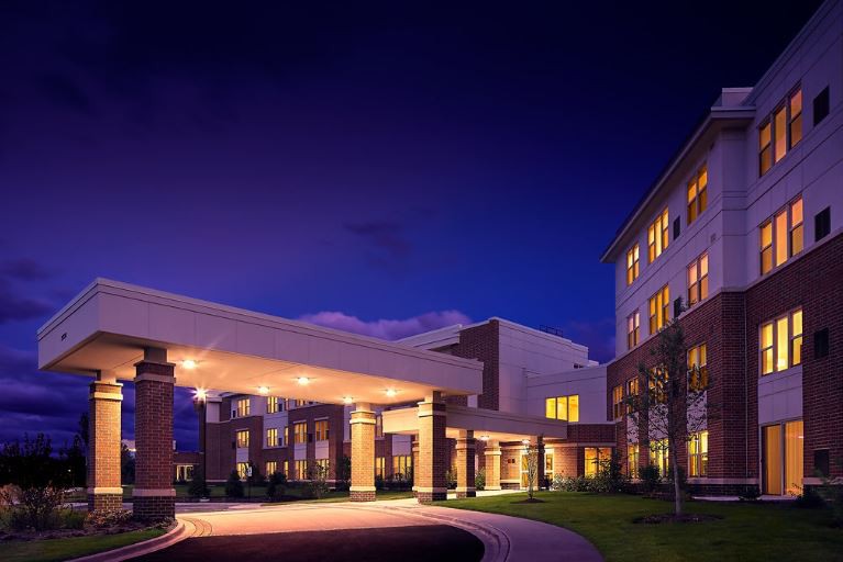 A well-lit building entrance at night showcasing modern architecture.