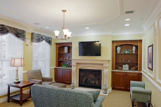 A cozy living room featuring a fireplace, modern furnishings, and built-in shelves.
