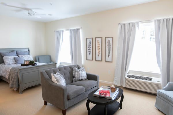 A cozy living room with a grey sofa, coffee table, and decorative wall art.