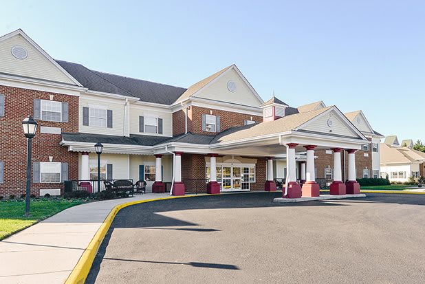 A two-story brick building with a prominent entrance and large windows.