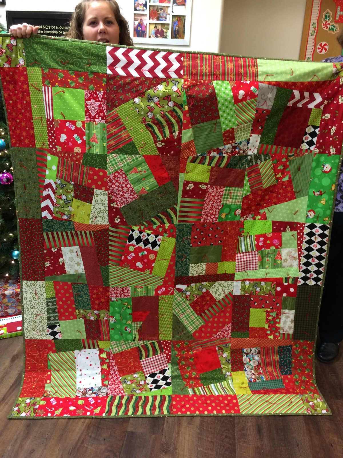 A vibrant patchwork quilt featuring a mix of red, green, and patterned fabrics.