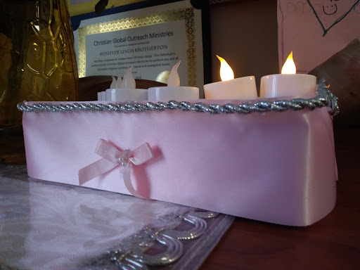 A decorative arrangement featuring illuminated candles on a pink base, adding a warm glow to the setting.