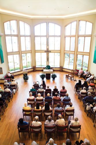 A community gathered for worship in a bright church interior.