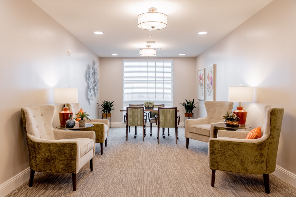 A modern living room with elegant seating, bright lighting, and decorative artwork.