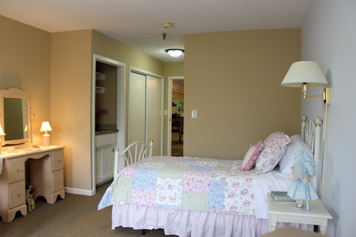 A cozy bedroom with pastel-colored bedding and simple decor.