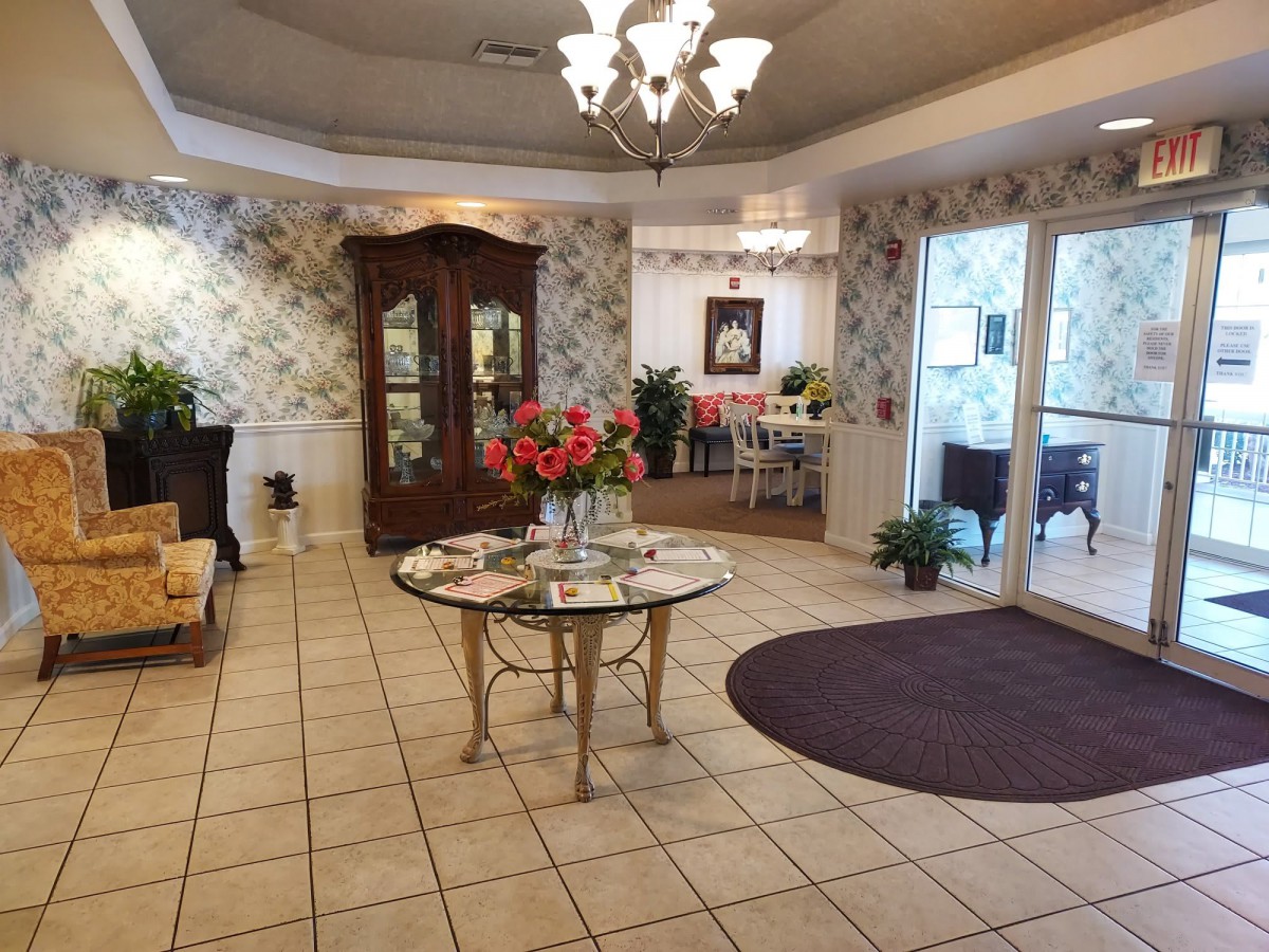 A cozy lobby area with elegant furniture, decorative plants, and warm lighting.