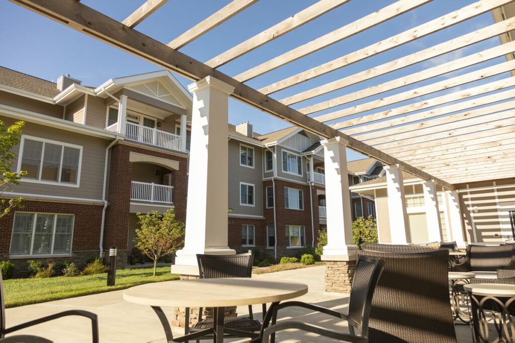 Outdoor seating area under a pergola at an apartment complex.