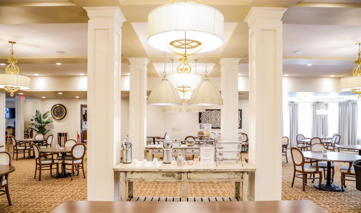 Elegant dining area with chandeliers and decorative pillars.