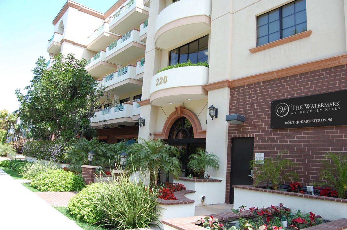 The exterior of a hotel building with balconies, surrounded by well-maintained landscaping and greenery.